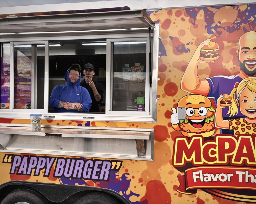 McPappy's friendly staff smiling at the camera through the food truck window